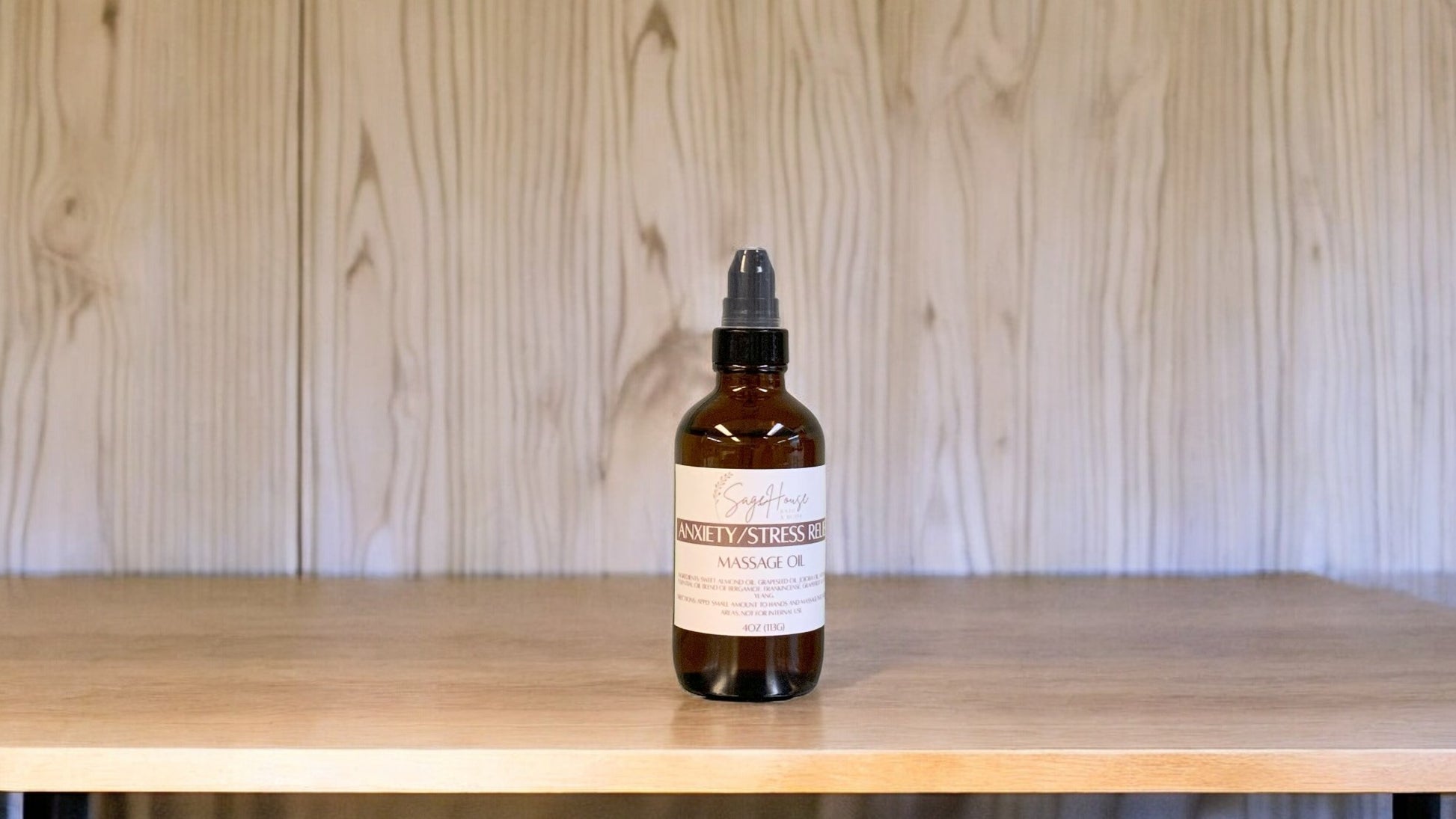 A Bottle with a treatment pump, labeled with 'Anxiety/Stress Relief Massage Oil', positioned on a wooden surface.