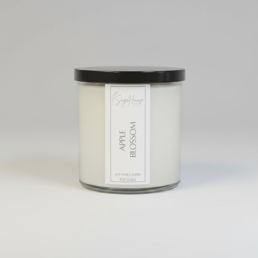 A white soy wax candle in a clear container, placed on a wooden surface, with a label on the front.