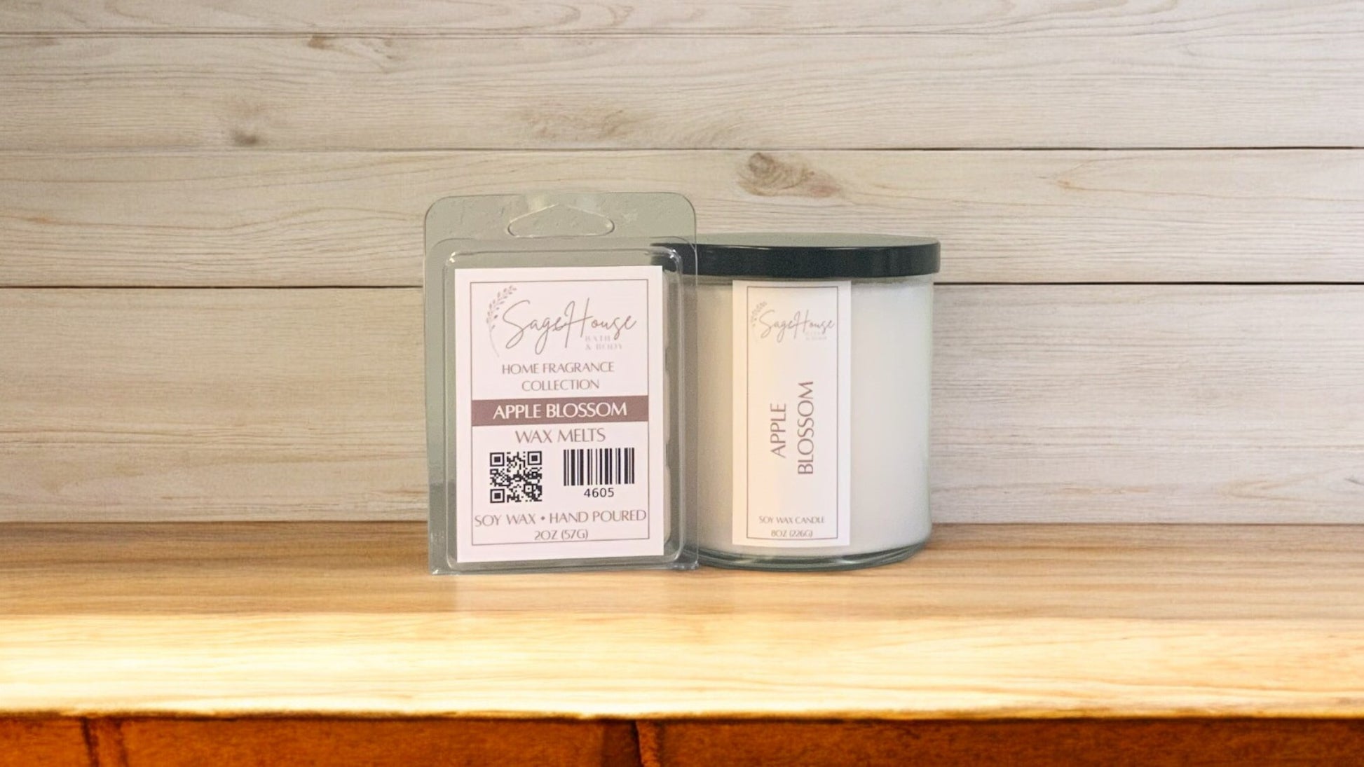 A white soy wax candle in a clear container, next to a clear clamshell wax melt package. placed on a wooden surface, with a label on the front.