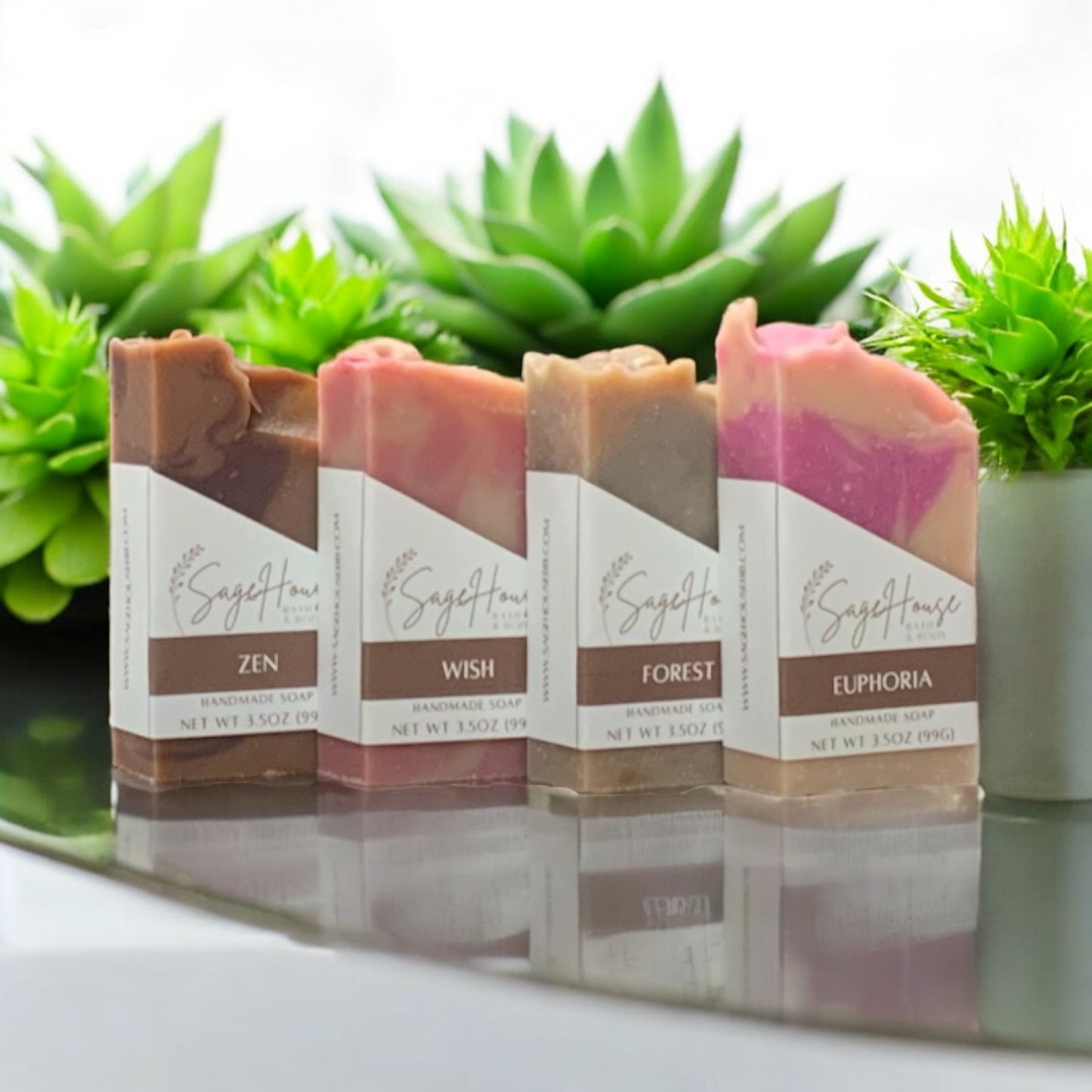Four soap bars with labels in front of green plants