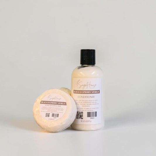 A round shampoo bar and bottle of conditioner, both labeled. Sitting on a white background.