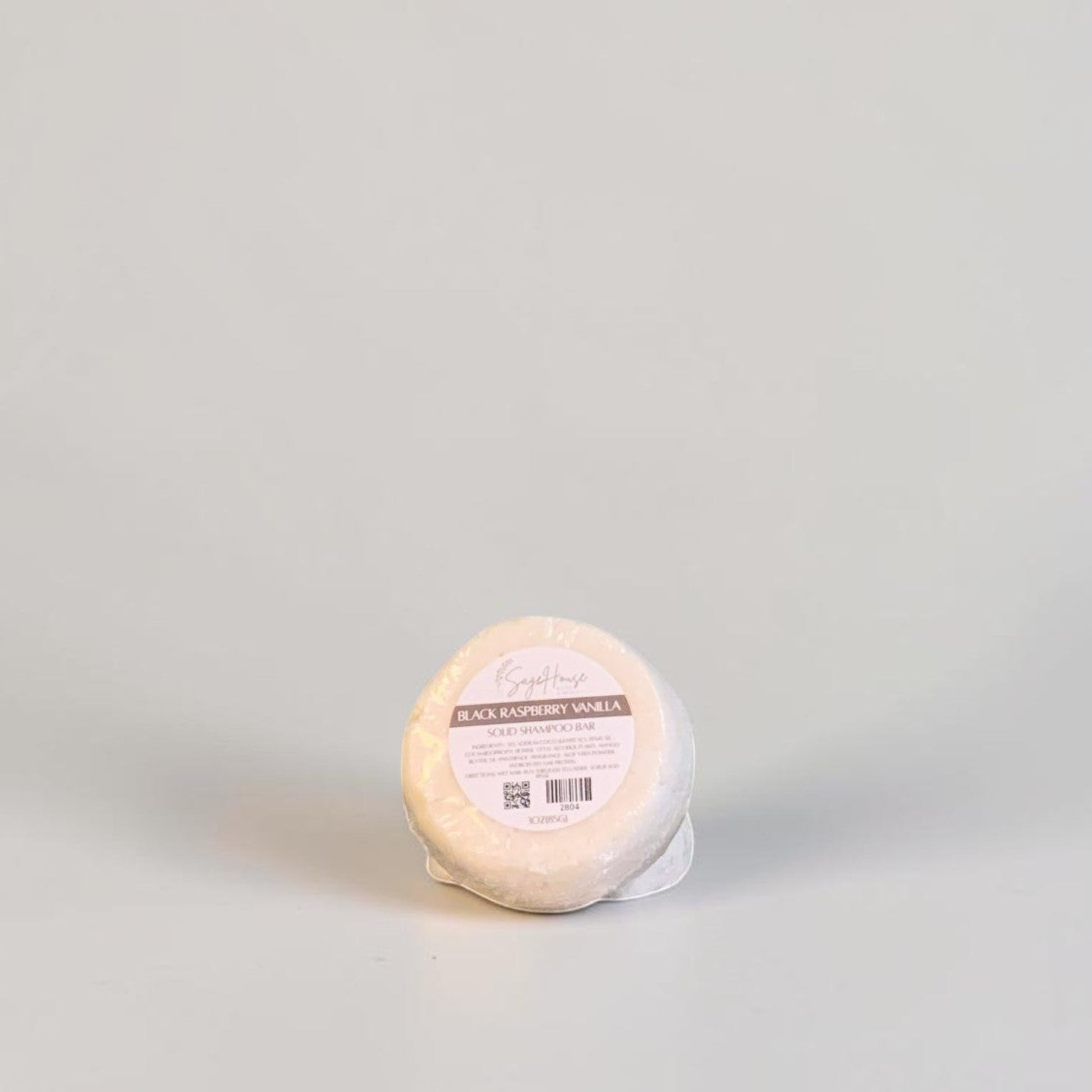 A round labeled shampoo bar on a white background.