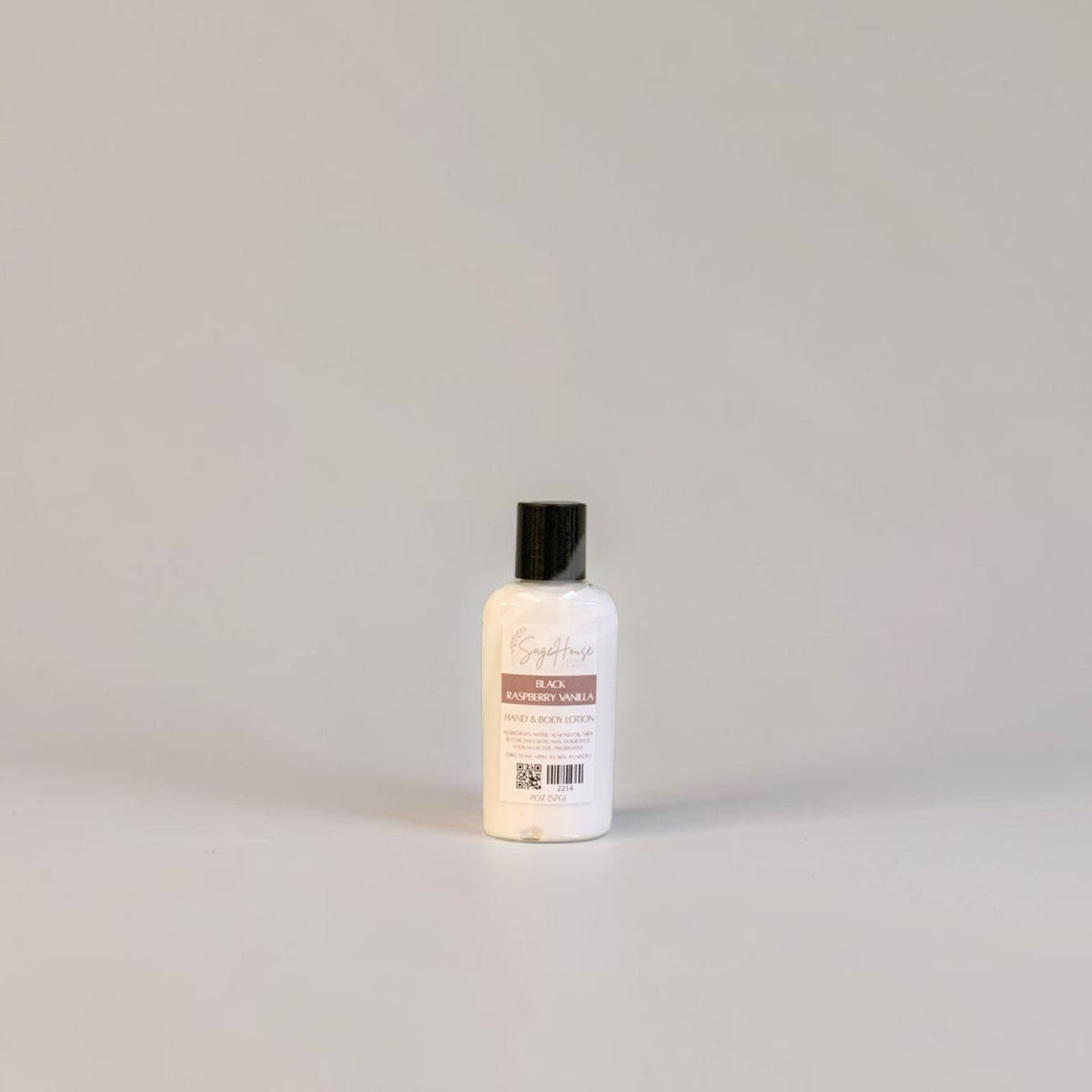 A small bottle of lotion with black cap and white label. On a white background.