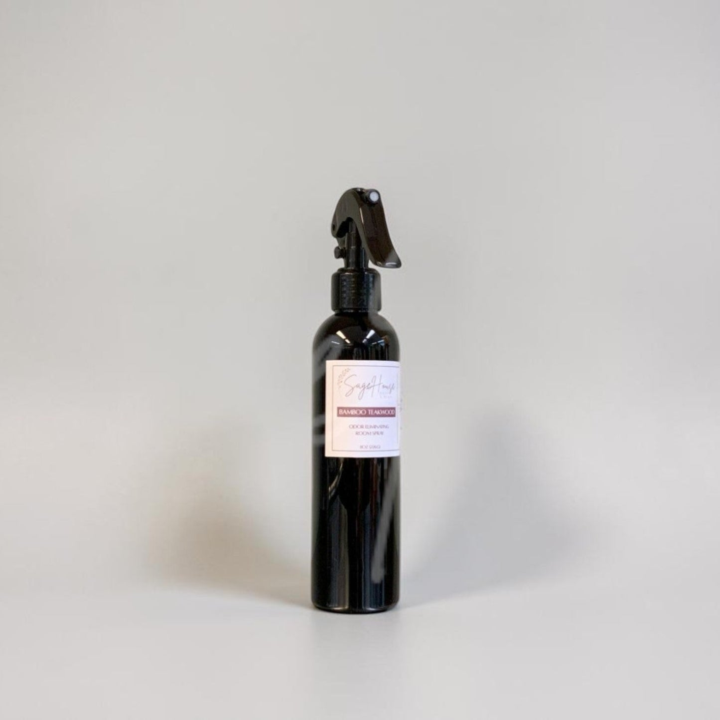 Black spray bottle with a label on a gray background