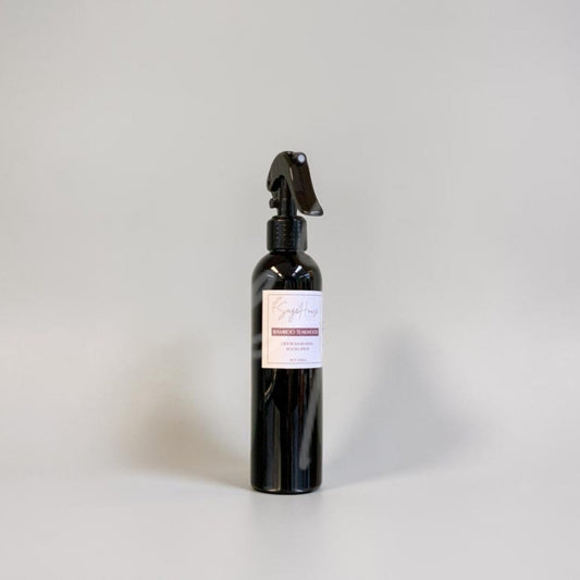 Black spray bottle with a label on a gray background