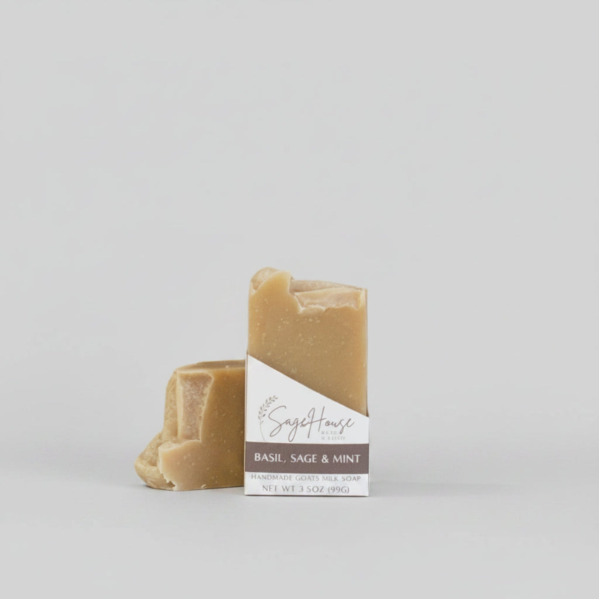 A tan bar of soap in a white labeled open box. on a wood surface.
