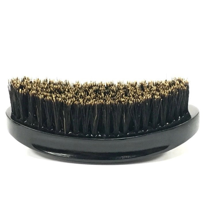 A gloss black beard brush with a metalic silver logo and long black bristles.