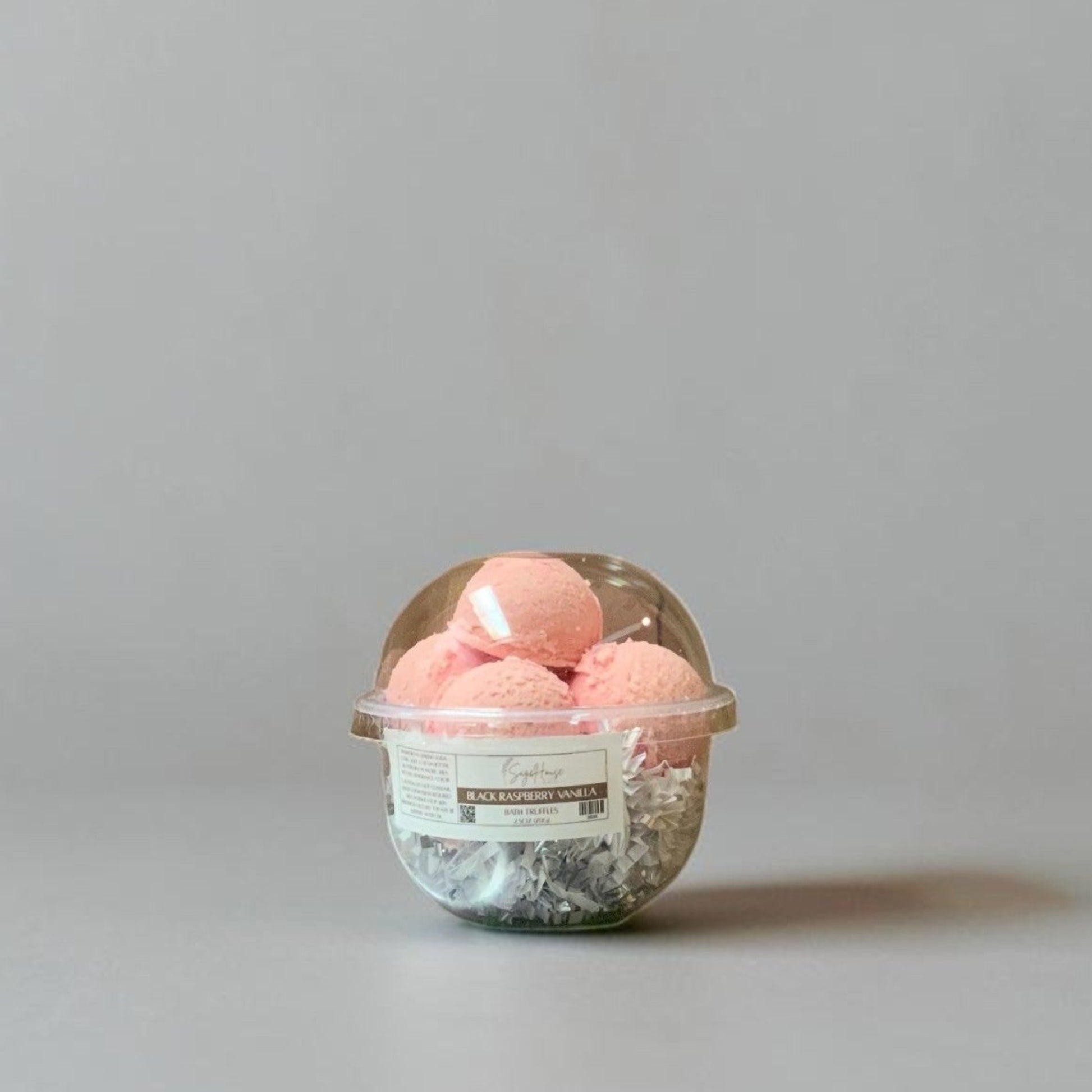 a container of bath truffles on a grey background.