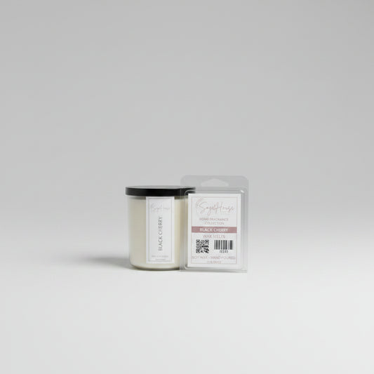 A white soy wax candle in a clear container, next to a clear clamshell wax melt package, placed on a wooden surface, with a label on the front.