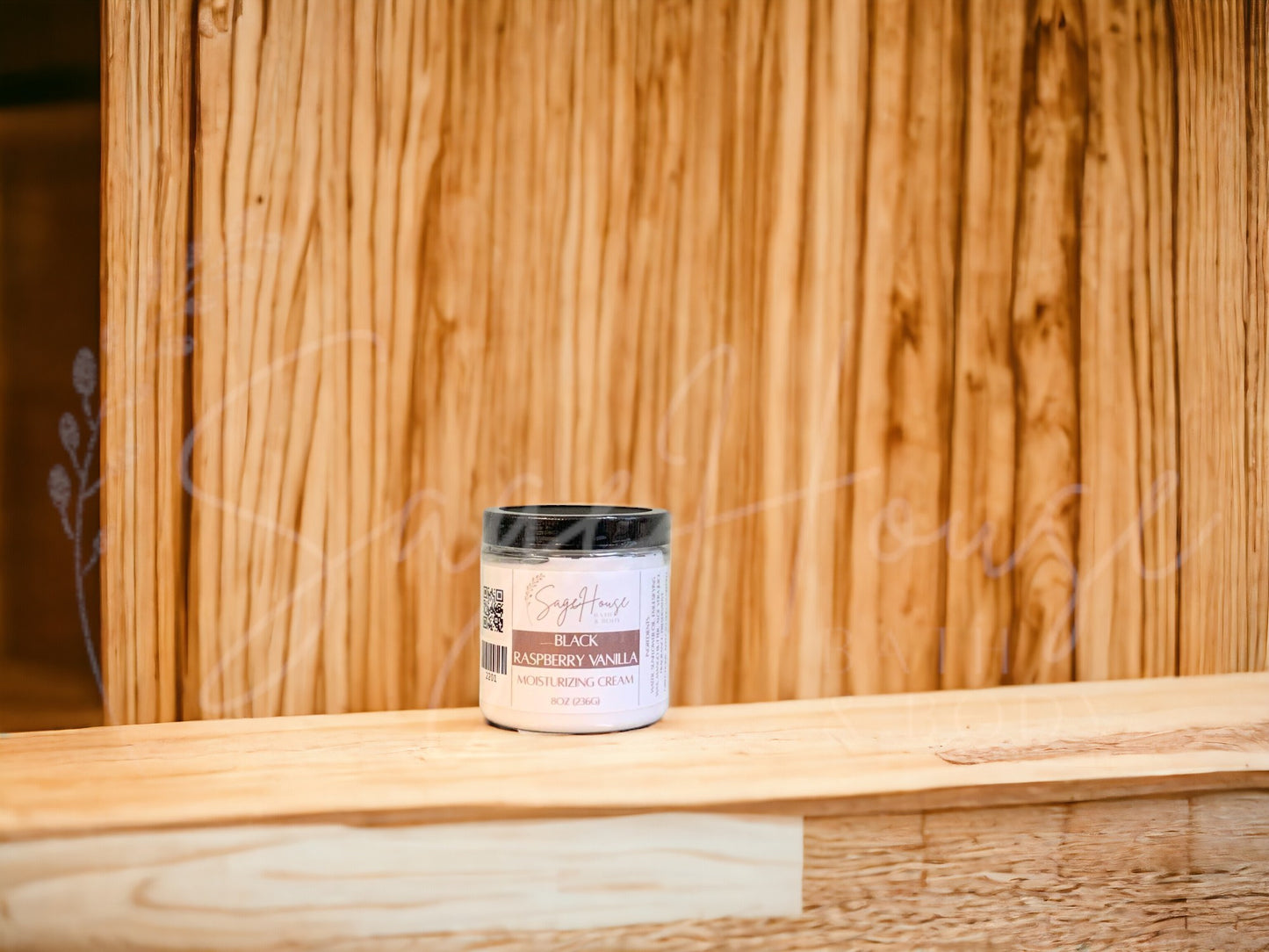 A jar of Black Raspberry Vanilla Moisturizing Cream with a wood background