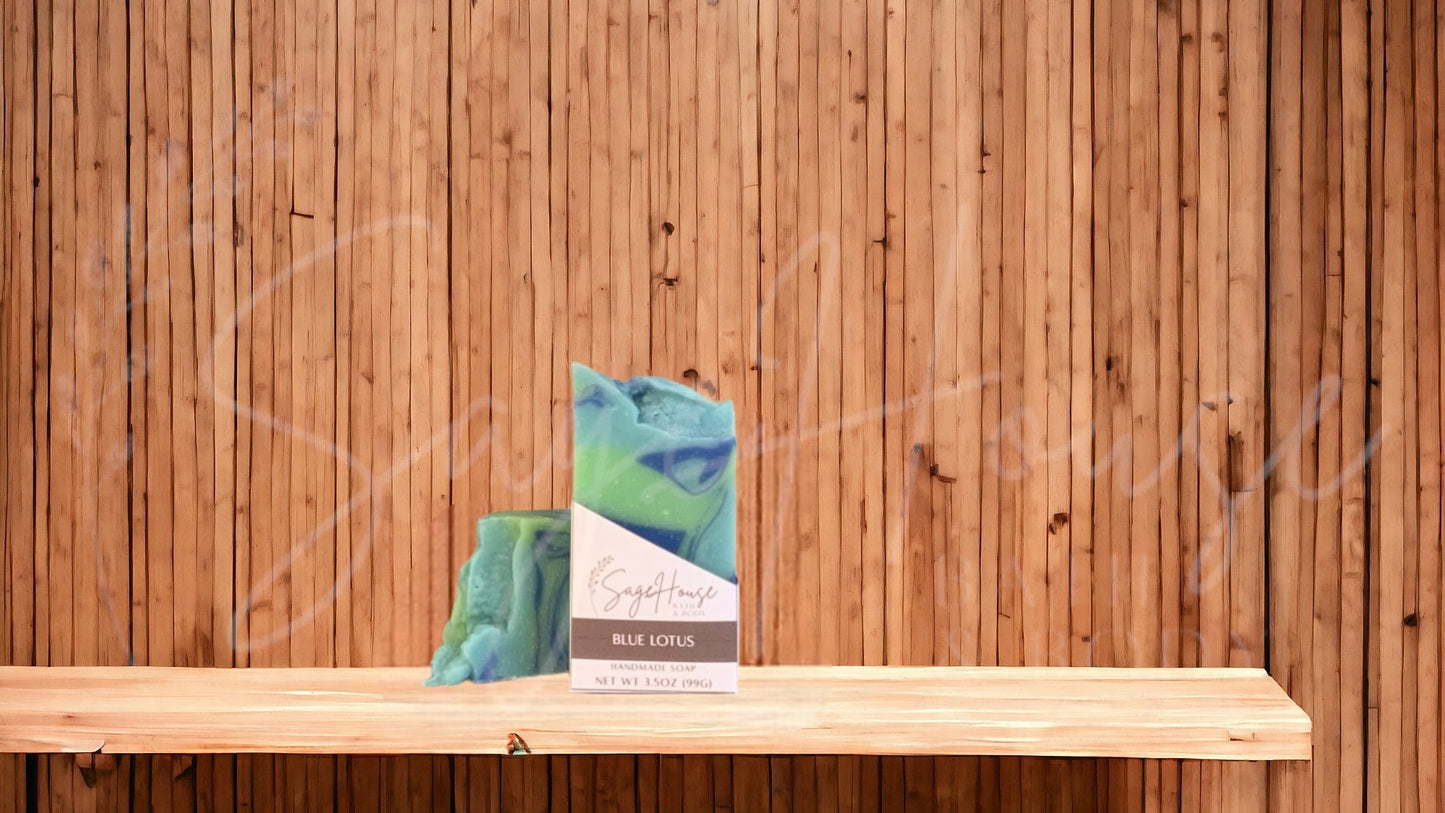A light teal colored bar of soap with dark blue and lime green accents with a white label. on a wood surface.