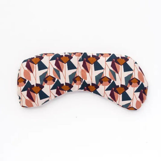 An eye mask therapy pack with a geometric pattern in multicolor, primarily in shades of orange, blue, and beige, displayed on a white background.