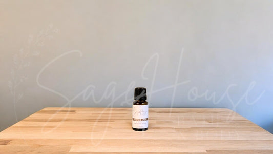 A small bottle of breathe easy blend essential oil is placed on a wooden surface with a plain background.