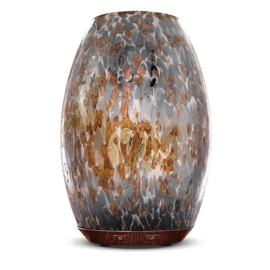 A hand-blown glass diffuser with a faux flame effect featuring warm white and colored light options.
