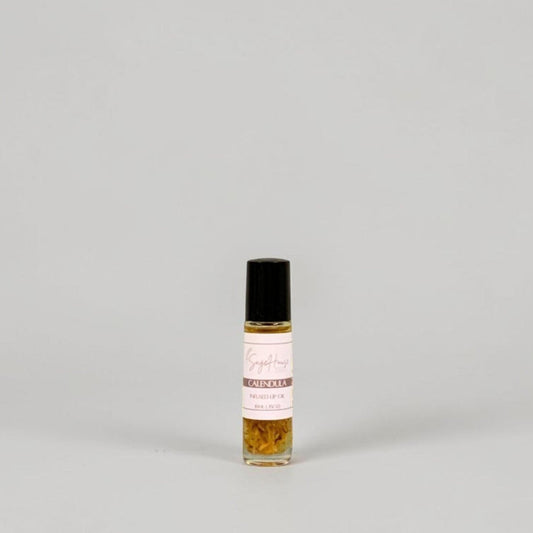A small glass roller bottle with a black cap and a white label, standing on a light gray background.
