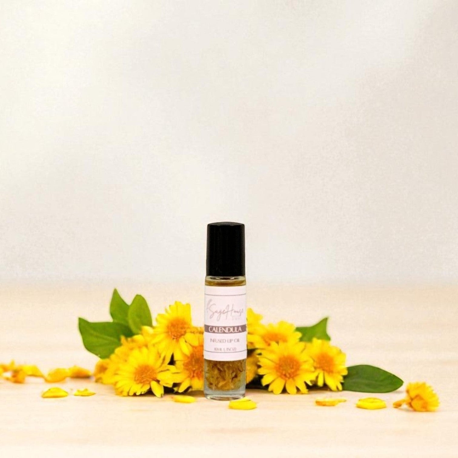 Small bottle of lip oil with yellow flowers surrounding, on a light background
