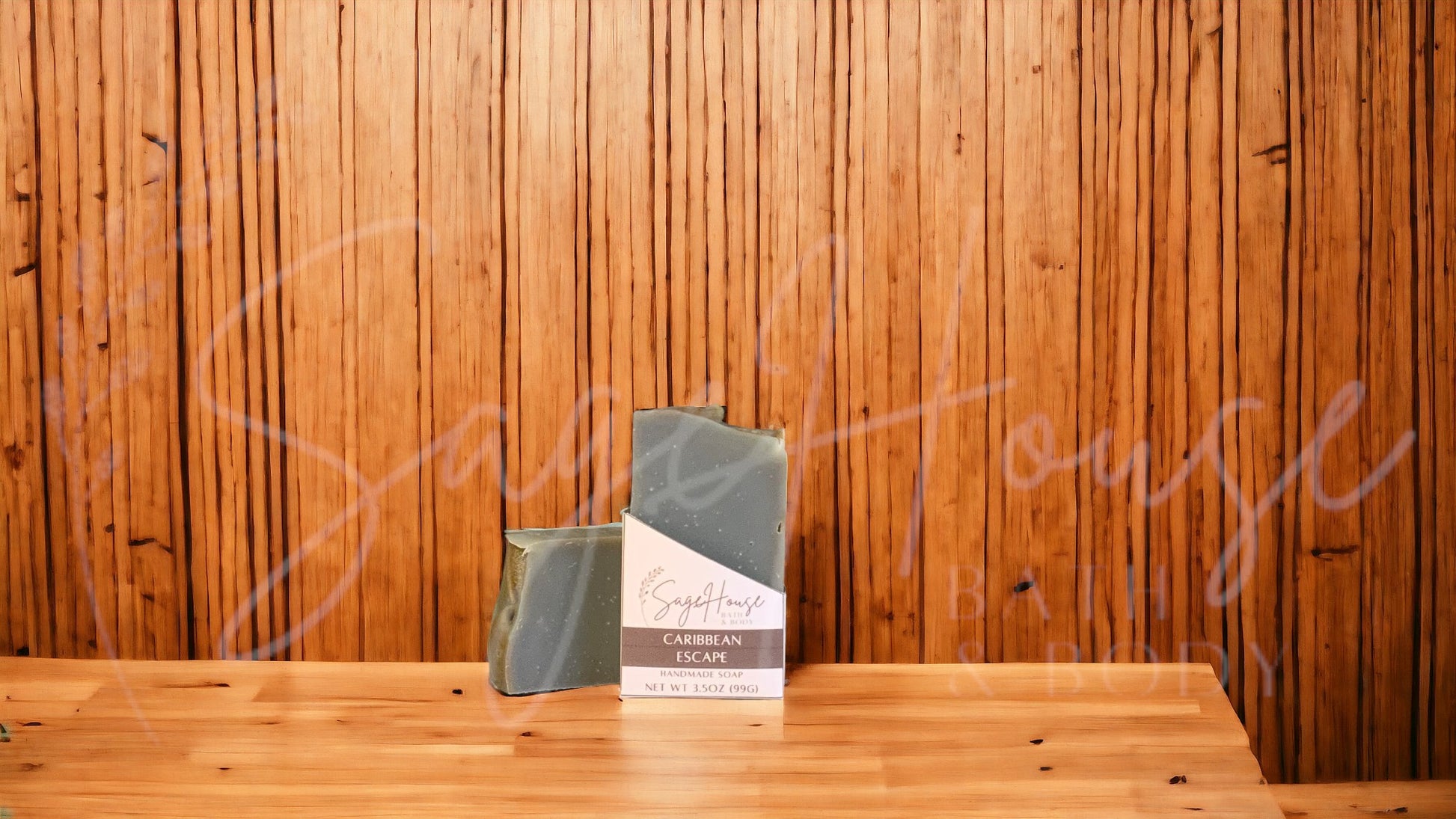 A dark teal colored bar of soap with brown accents in a white labeled box, on a wood surface.