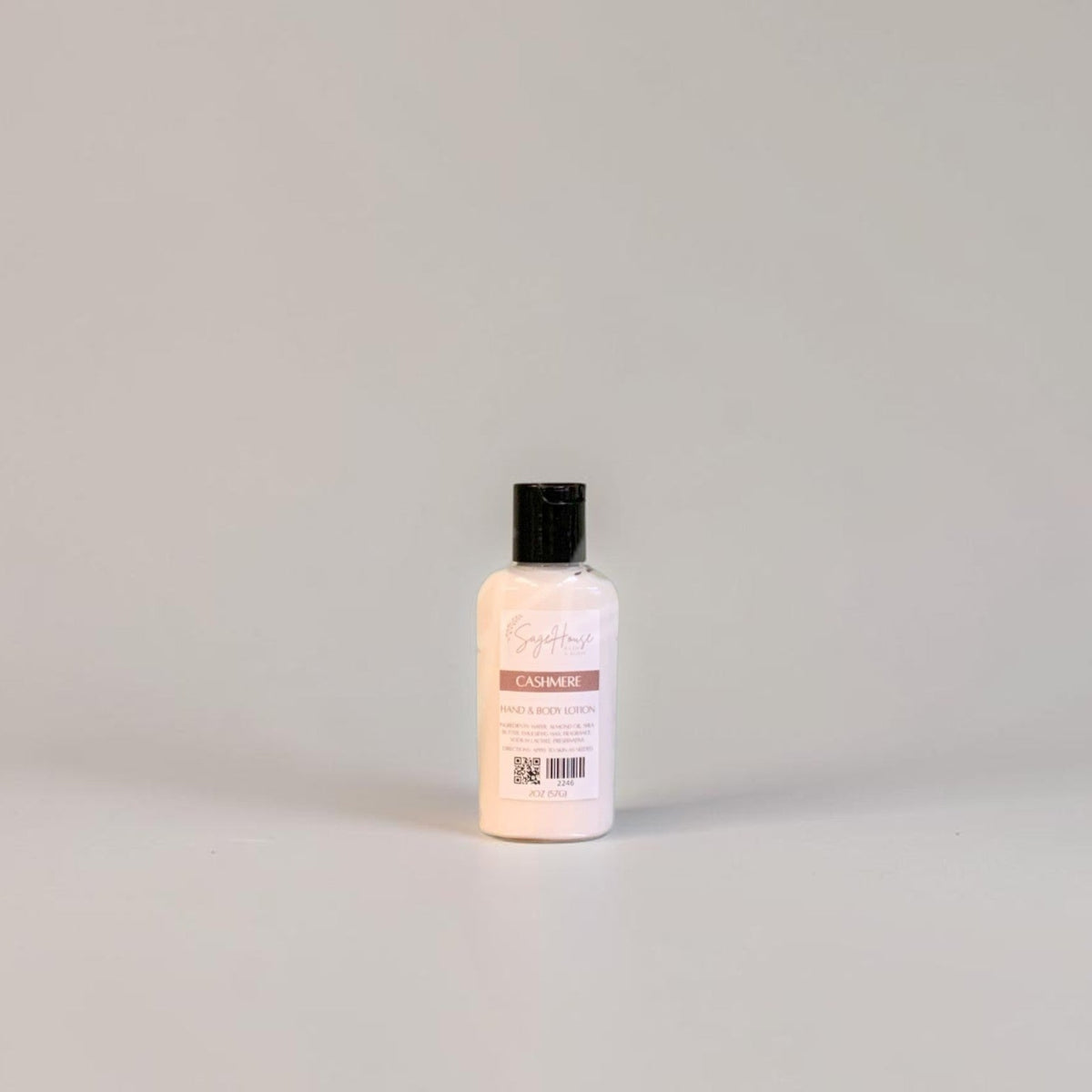 A small bottle of lotion with black cap and white label. On a white background.