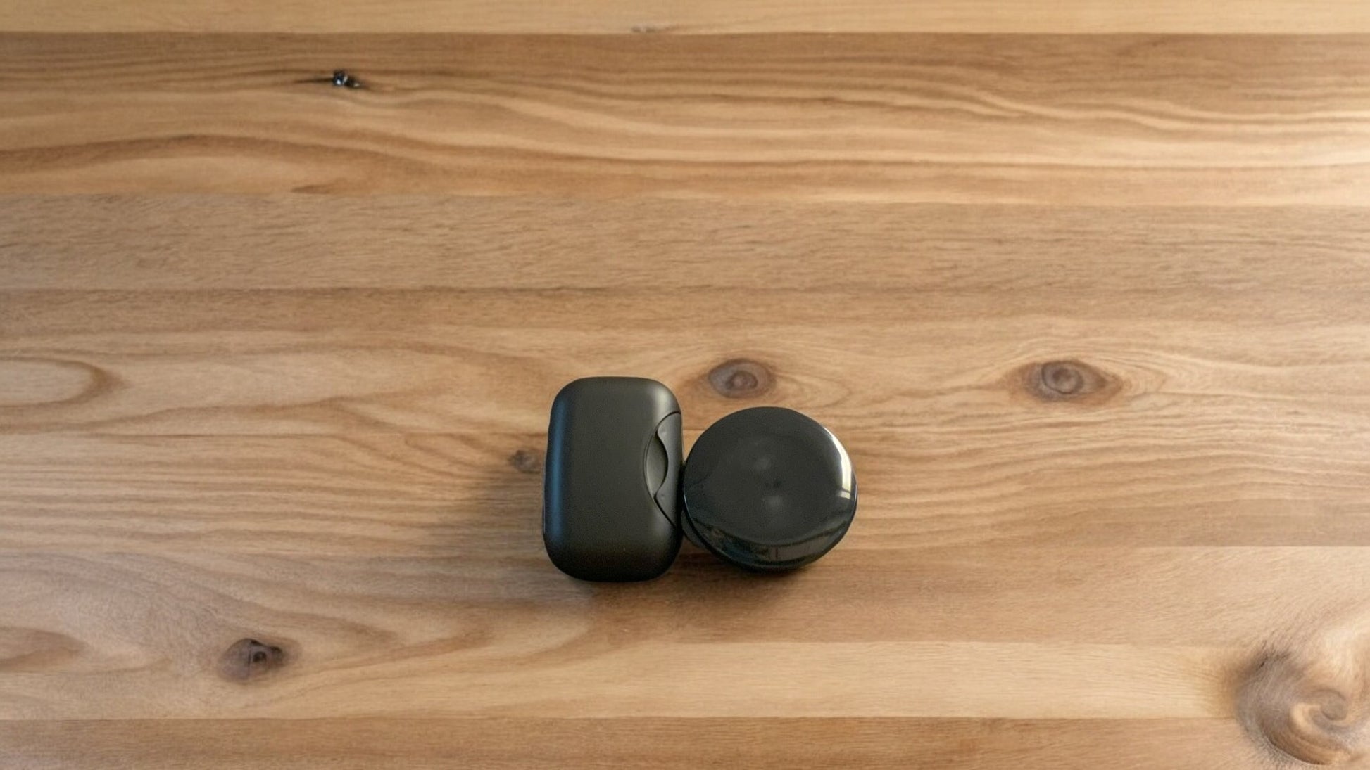 Two black travel cases, placed on a wooden surface.