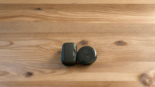 Two black travel cases, placed on a wooden surface.