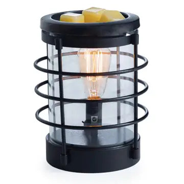 A black Coastal Wax Melt Warmer with a vintage bulb. The device has a glass dish with a wax melt inside and a metallic finish on a solid background.