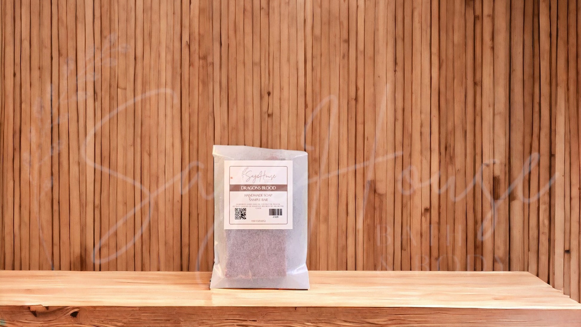A sample bar of soap in a glassine bag. placed on a wood surface.