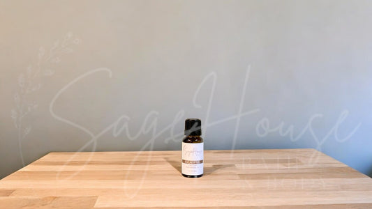 A small bottle of eucalyptus radiata essential oil is placed on a wooden surface with a plain background.