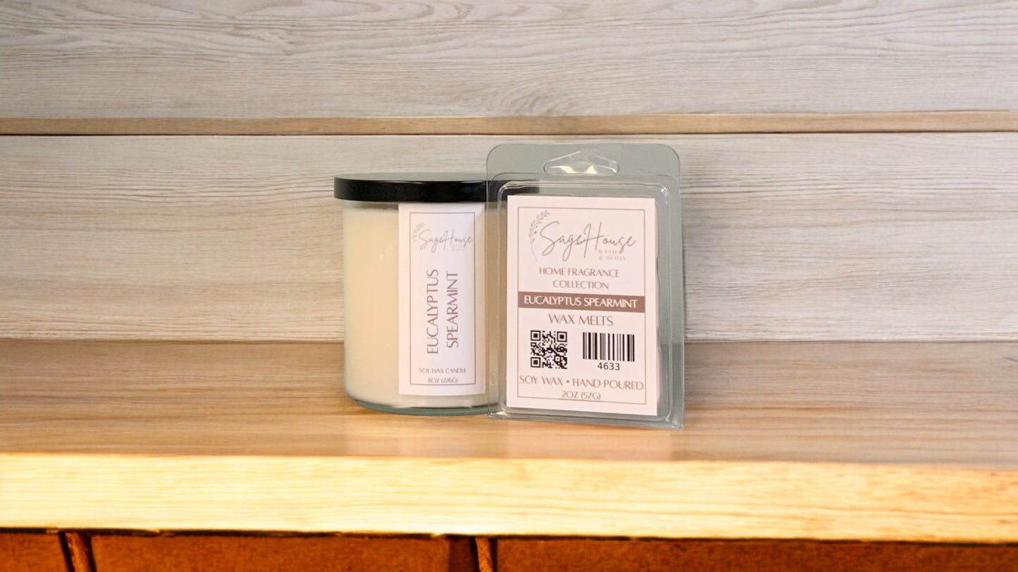 A white soy wax candle in a clear container, next to a clear clamshell wax melt package. placed on a wooden surface, with a label on the front.