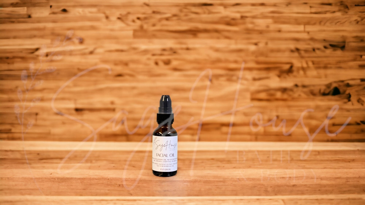 A bottle of facial oil with dispenser top on a wooden background.