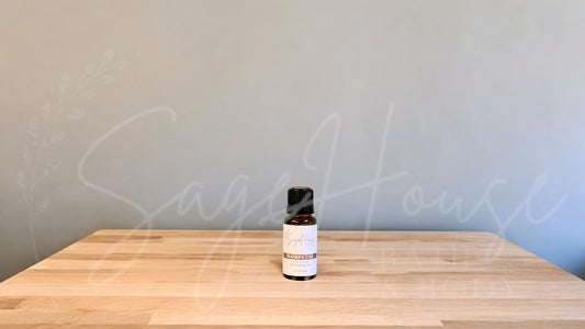 A small bottle of frankincense essential oil is placed on a wooden surface with a plain background.