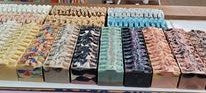 A variety of colored full loaves of uncut soap lined up side by side