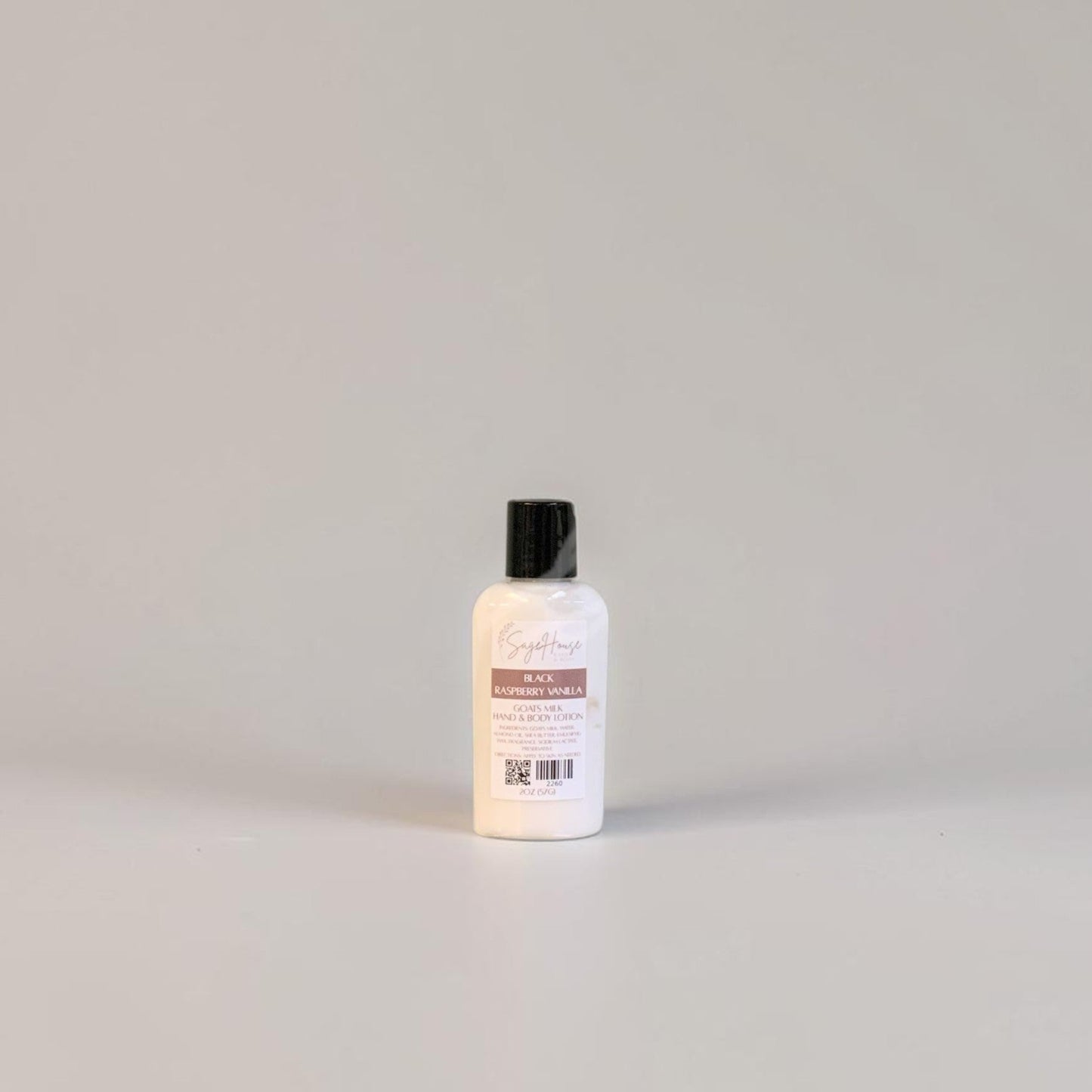 A small bottle of lotion with a black cap and white label. On a white background.