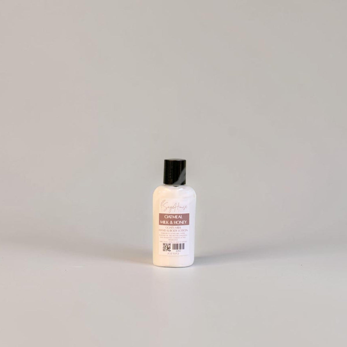 A small lotion bottle with black cap and white label on a white background.