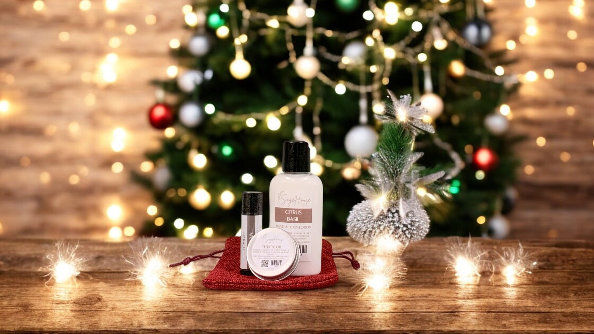 various bath and body products, sitting on a red bag. wood surface with pine cones and greenery in the background