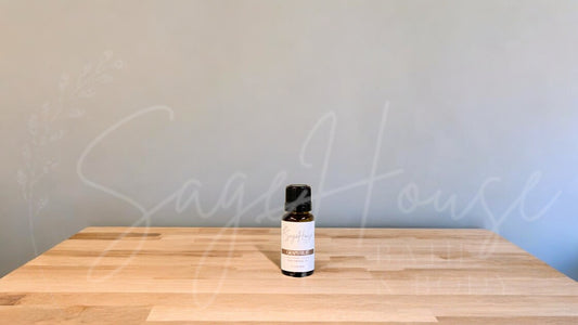 A small bottle of grapefruit essential oil is placed on a wooden surface with a plain background.