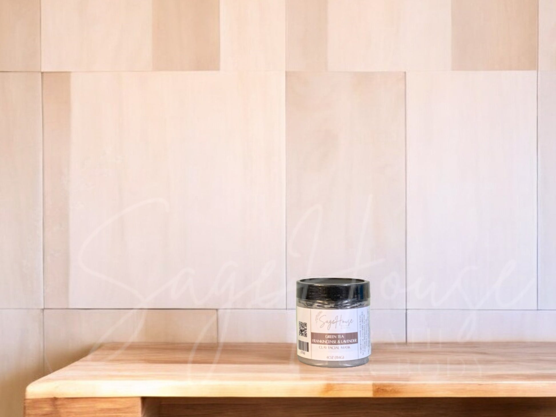 A face mask product in a small container, with a beige background resembling a wooden texture.