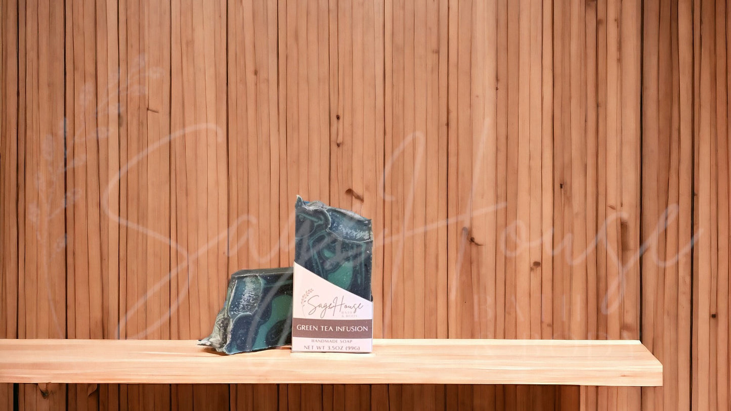 A black colored bar of soap with dark green accents, in a white labeled box, on a wood surface.