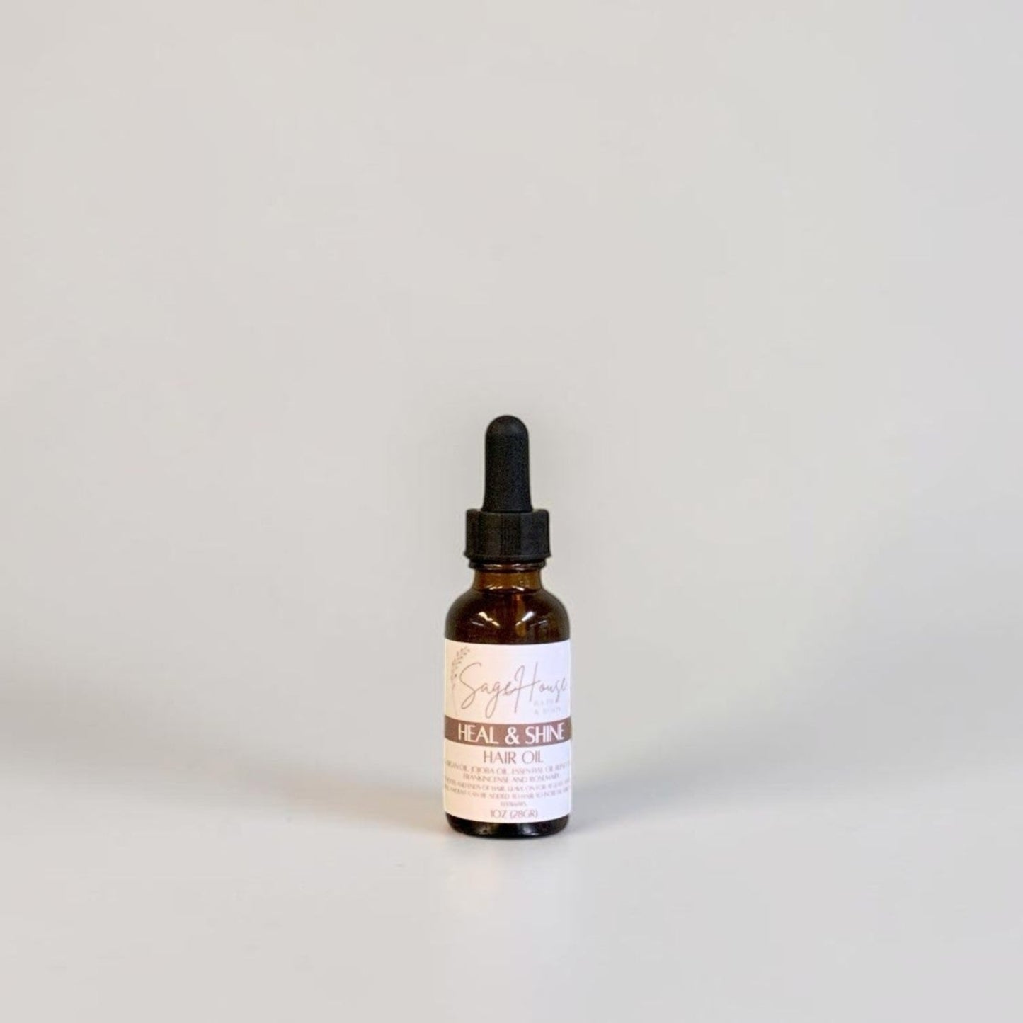 A small amber glass dropper bottle with a black dropper cap and a white label, centered against a plain light gray background.