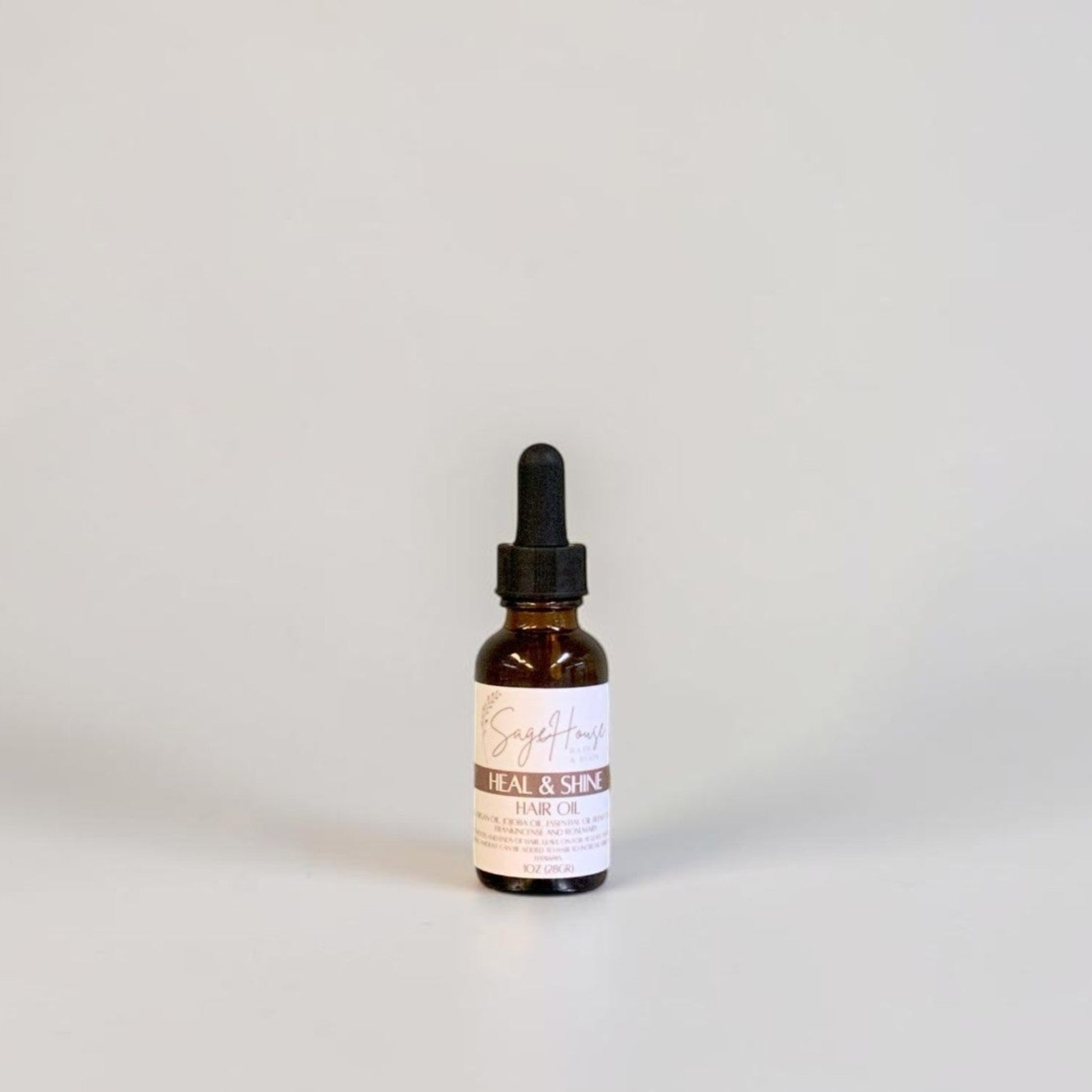 A small amber glass dropper bottle with a black dropper cap and a white label, centered against a plain light gray background.