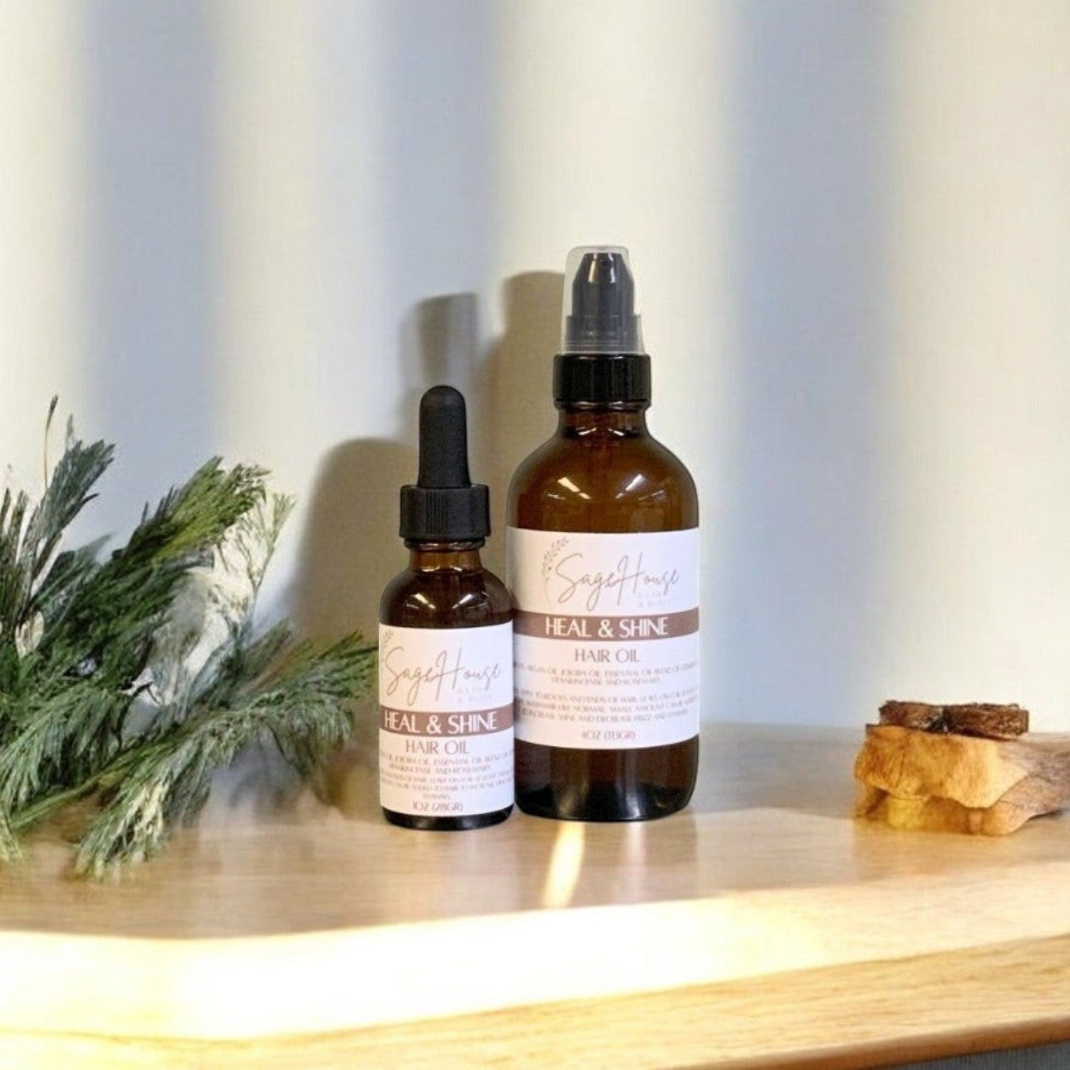 Two sizes of bottles, of scalp and hair oil on a wooden surface with a light background