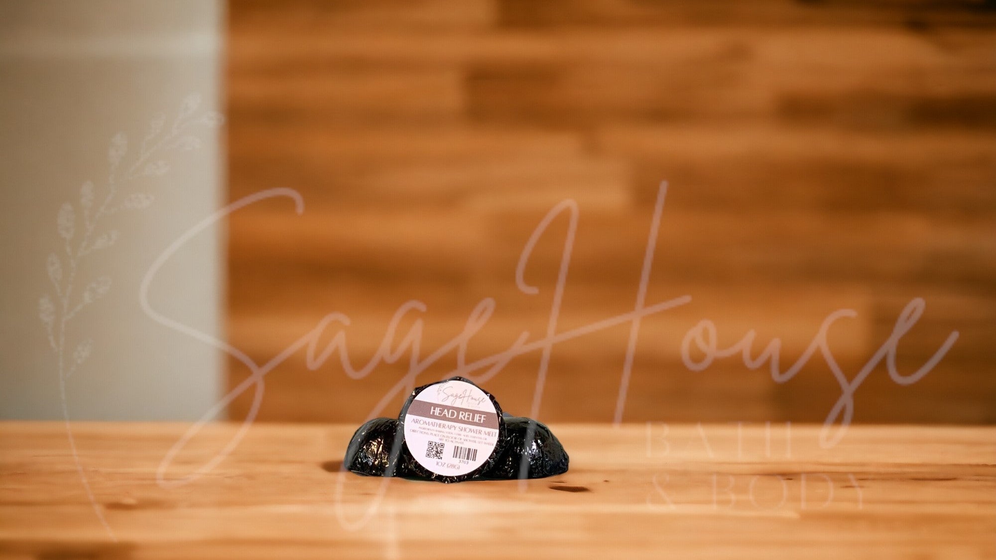 Aromatherapy shower melt in black packaging labeled "head relief", on wood surface