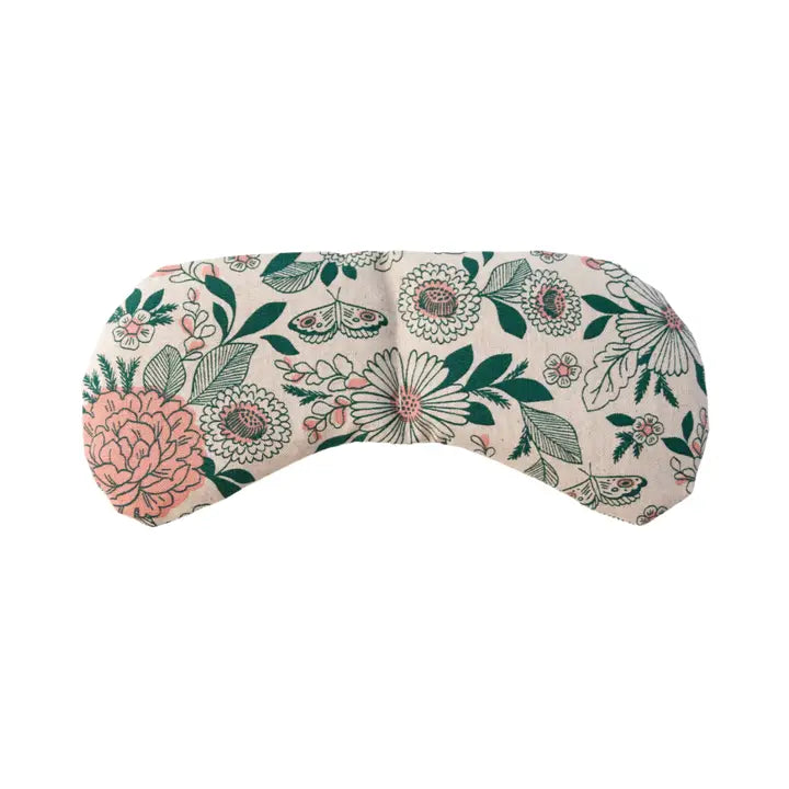 An eye mask therapy pack with a floral pattern in neutral colors of green, pink & beige. displayed on a white background.