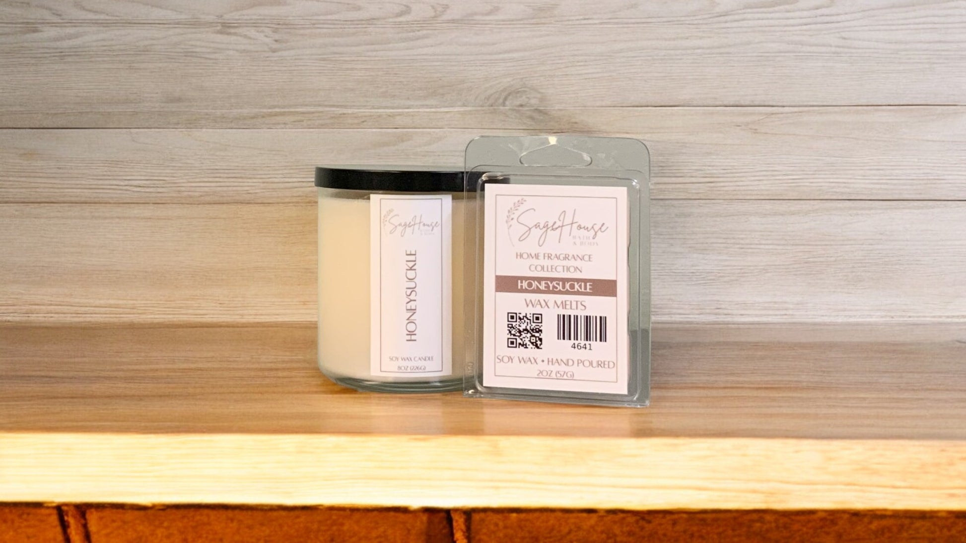 A white soy wax candle in a clear container, next to a clear clamshell wax melt package. placed on a wooden surface, with a label on the front.