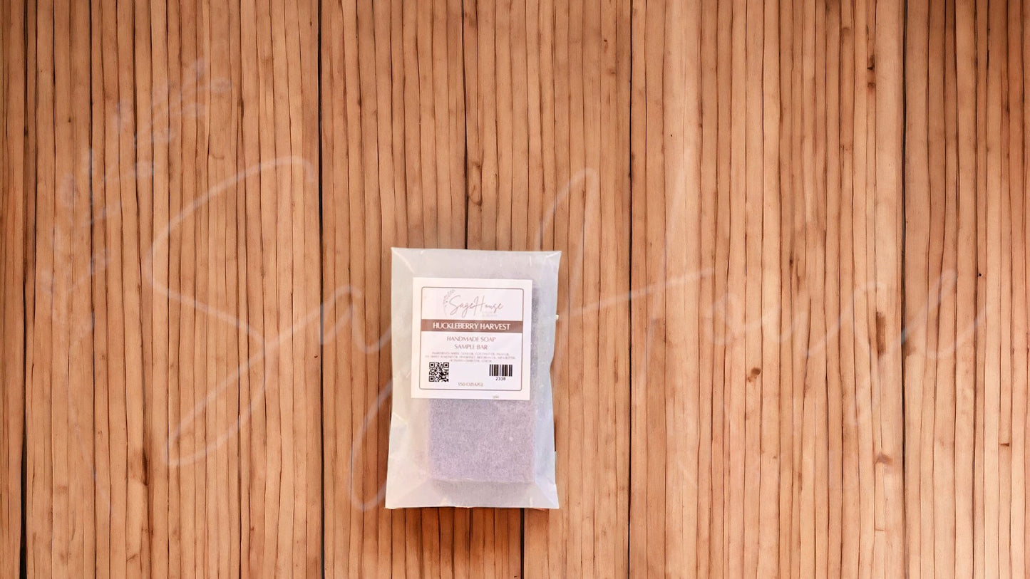 A sample bar of soap in a glassine bag. placed on a wood surface.