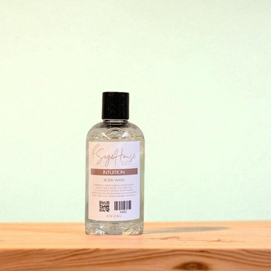 Bottle of "intuition" body wash on a wooden surface with a light background