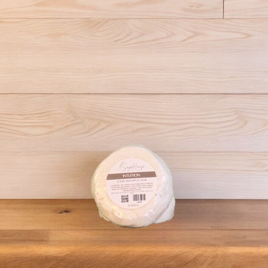 A bar of Intuition shampoo on a wooden surface.