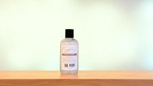 Bottle of "kansas sunset" body wash on a wooden surface with a light background