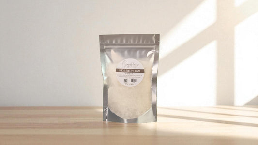 Silver packaging with a clear window of white salt labeled "kids sleepy time" on a wood surface.