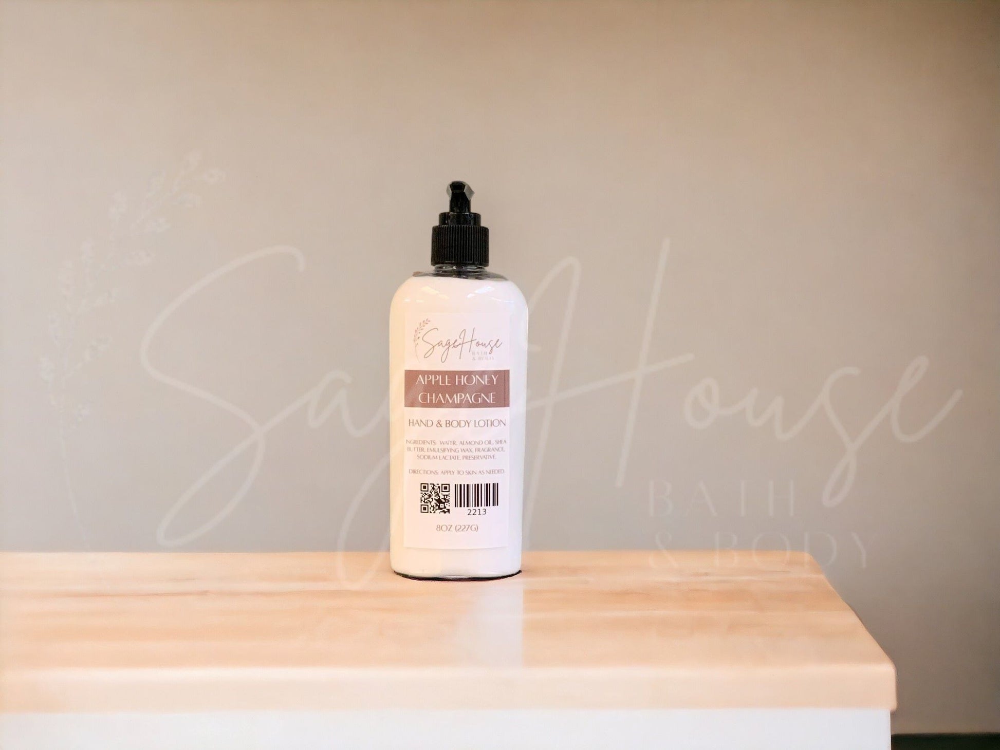A large bottle of lotion with a black pump top. Sitting on a white countertop with neutral background