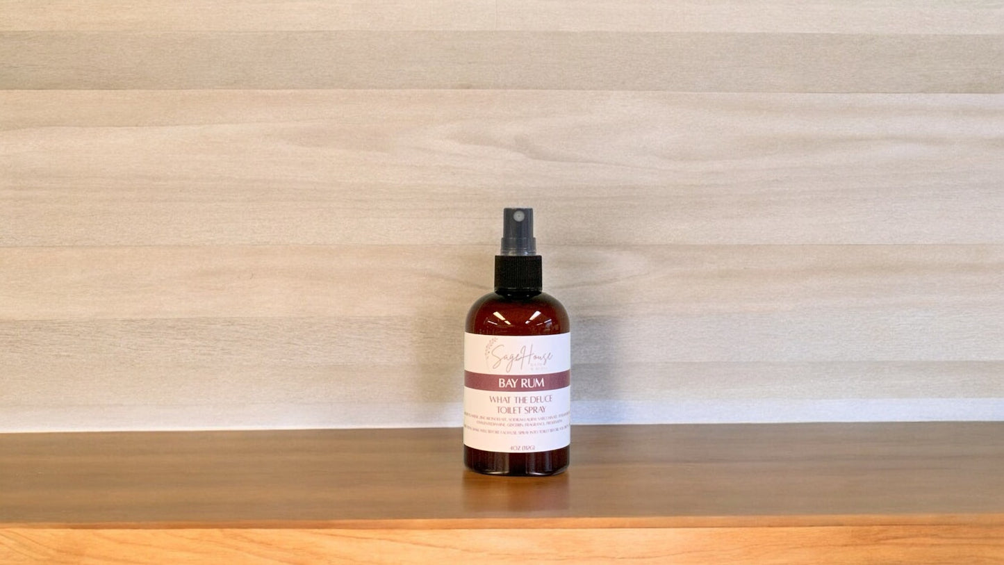 Amber colored spritz bottle with bay rum label, on wood surface